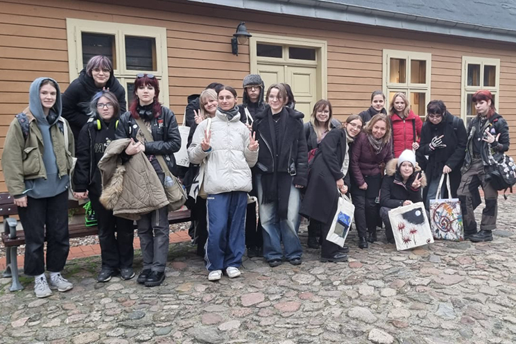 grupa uczniów na tle skansenu